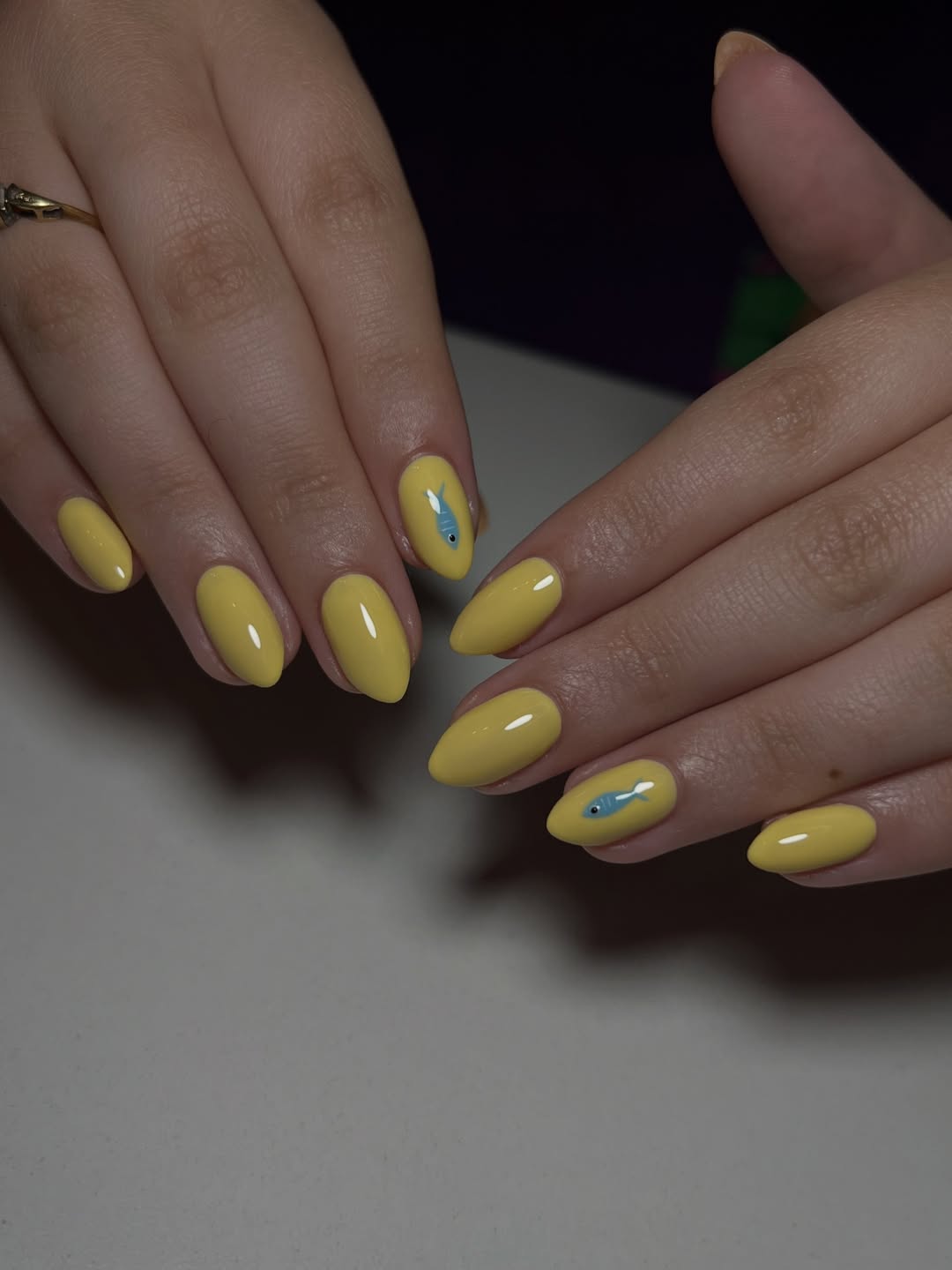 Sunny Yellow Glossy Almond Nails With Blue Fish Art